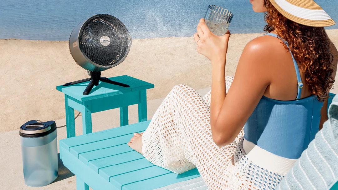 Woman using FlexBreeze Pro Mist fan on the beach