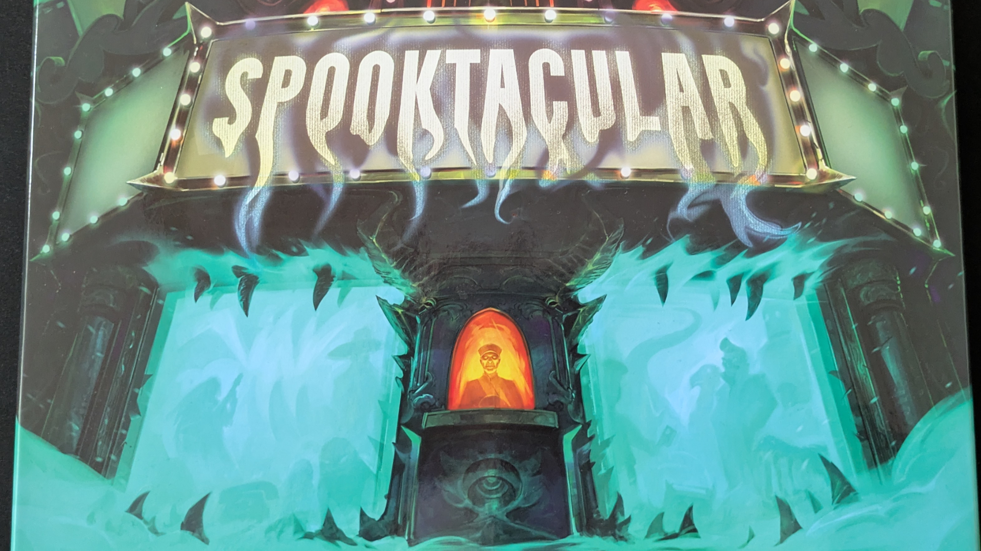 Spooktacular box art featuring a movie theater suffused with eerie green light